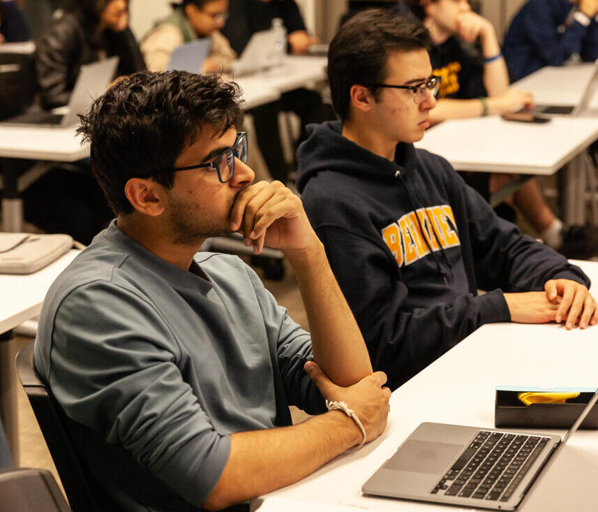 Two students looking sitting at desk and pensively forward